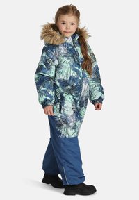 Paminkštintas žiemos snowsuit su mėlynu ir žaliu gėlių raštu, kailiniu pamušalu kapuce, užtrauktuku ir mėlynomis nepralaidžiomis kelnėmis. Juodi batai užbaigia aprangą.