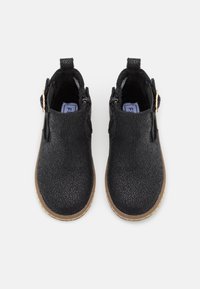 Černé kotníkové boty s texturovaným povrchem, zipy po obou stranách a hnědou gumovou podrážkou. Obsahují poutko pro snadné obutí.