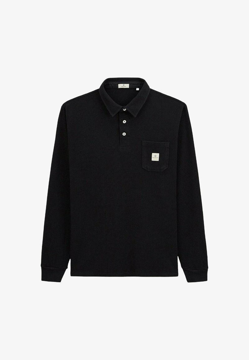 Polo noir à manches longues en tissu texturé. Doté d'un col, d'une patte de boutonnage à trois boutons et d'une poche poitrine gauche avec une étiquette.