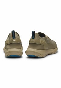 Beige Sportschuhe mit Mesh-Obermaterial, strukturierten Details und kontrastierenden dunkelblauen Akzenten an der Ferse. Verfügt über eine robuste, geformte Sohle.