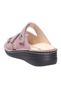 Pink suede open-back slipper with black cushioned sole, adjustable straps, and decorative silver flower charm on one strap.