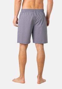 Shorts de bain pour hommes en tissu bleu marine avec un motif de petits points blancs, taille élastique et longueur au-dessus du genou.