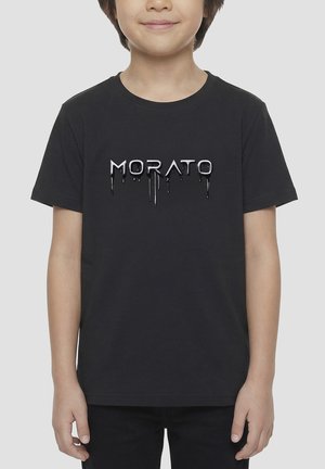 Niño con camiseta negra de manga corta con "MORATO" impreso en letras negras brillantes y goteantes en el frente.