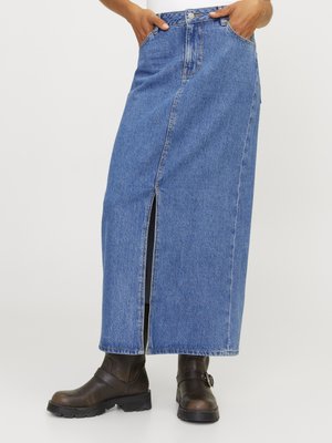 Denim max krilo v modri barvi, s sprednjim razporkom, visokim pasom in stranskimi žepi. V kombinaciji s temno rjavimi škornji. Gladka tekstura, klasičen dizajn.