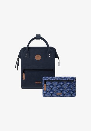 Marineblaues Rucksack aus strukturiertem Material mit einem runden Logo und einer vorderen Reißverschlusstasche. Enthält ein passendes, gemustertes Täschchen mit Reißverschluss.