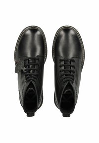 Bottines en cuir noir avec bout rond, lacets à l'avant et semelle texturée. Elles présentent des coutures décoratives et une languette à l'arrière.