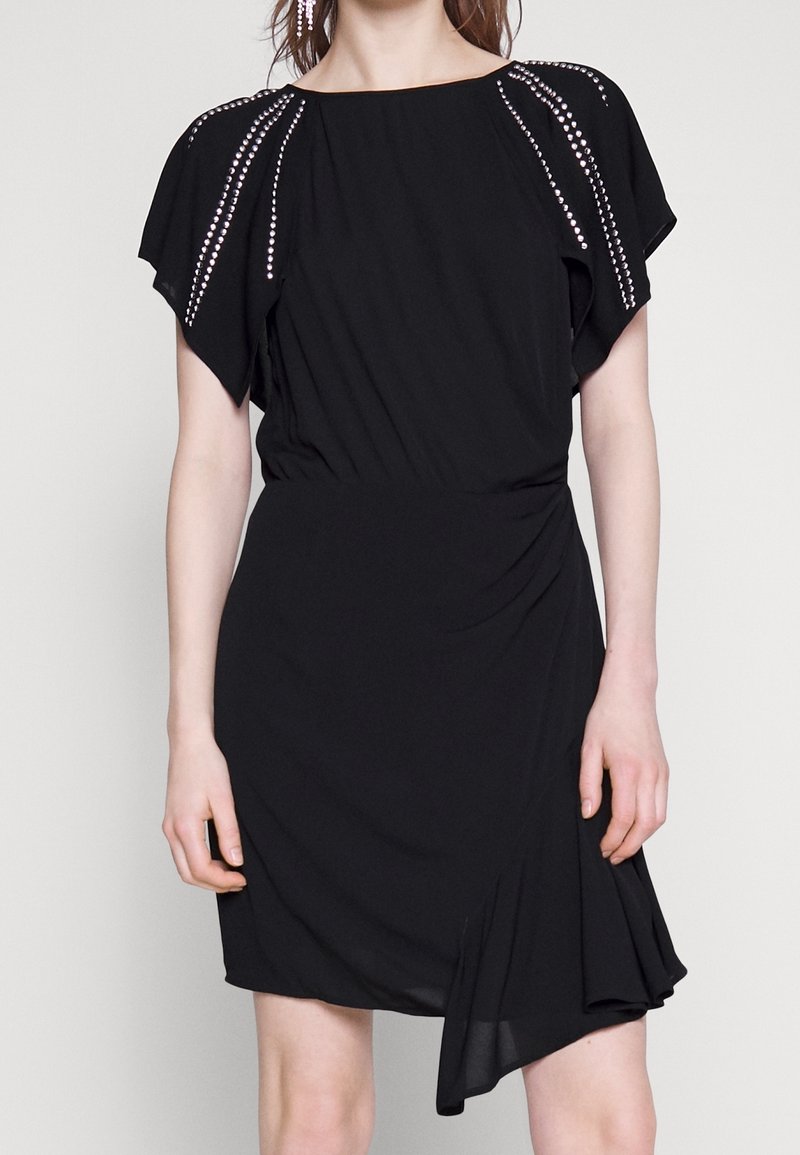 Black dress with short, draped sleeves. Features rhinestone accents along the shoulders, a fitted waist, and a wrap-style skirt.