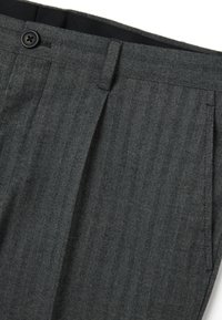 Pantaloni grigi a spina di pesce con un tessuto testurizzato, caratterizzati da pieghe, chiusura frontale con bottone e tasche laterali.