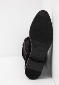 Czarne zamszowe botki za kostkę z teksturowaną gumową podeszwą i subtelnym zapięciem bocznym. Obcas jest płaski, a design jest smukły. Rozmiar 37.