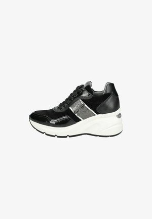 Black sneaker featuring glossy leather and suede accents, a white thick sole, grey panel, and black laces. Side logo detail present.
