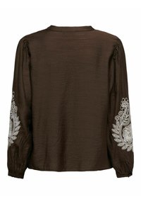 Brun langærmet bluse med en tekstureret overflade, prydet med hvide broderede blomster mønstre på ærmerne og en rund halsudskæring.