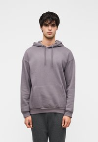 Γκρι φούτερ με απαλό ύφασμα, με τσέπη καγκουρό, κουκούλα με κορδόνι και ριμπ τελείωμα, συνδυασμένο με γκρι φόρμα.