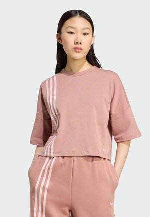 Camiseta corta rosa con mangas cortas que presenta rayas verticales blancas en un lado. Fabricada con un material suave y de corte relajado.