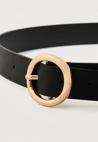 Ceinture en cuir noir avec une boucle ronde dorée brillante, montrant les trous de ceinture et la pointe sécurisée à travers un trou.