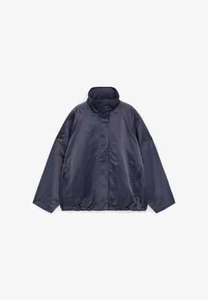 Chaqueta extragrande color azul marino oscuro con cuello alto, mangas largas, bolsillos laterales y dobladillo ligeramente fruncido sobre fondo blanco.