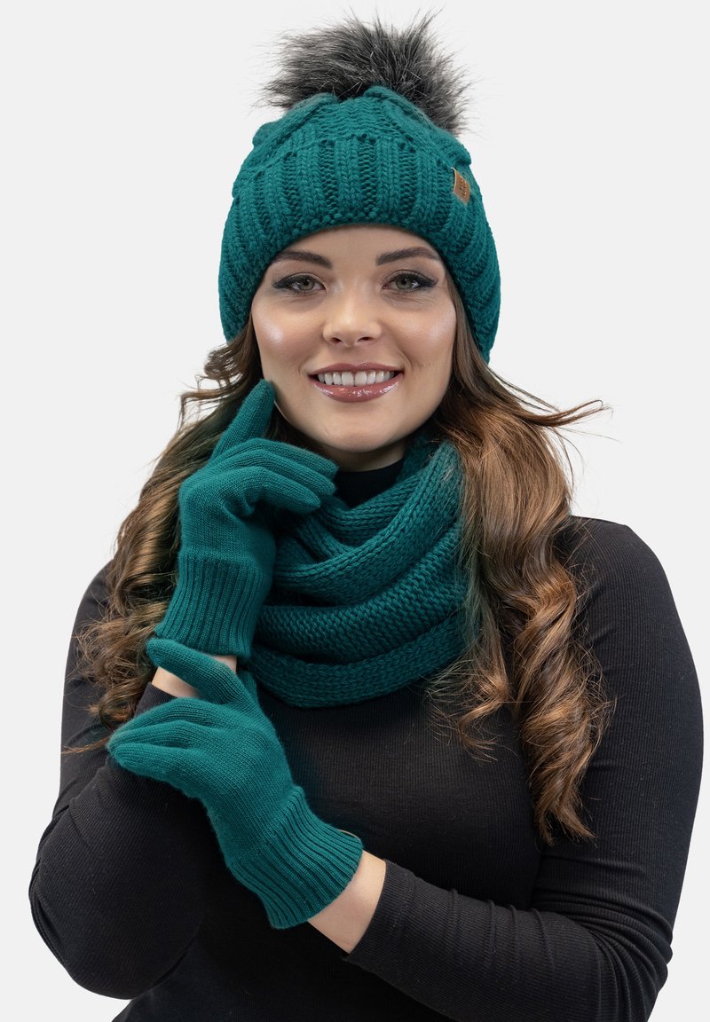 Türkiser Strickmütze mit Pompon, passendem Schal und Handschuhen. Das Set zeichnet sich durch ein strukturiertes Muster, weichen Stoff und gerippte Abschlüsse aus.