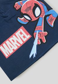 Granatowy materiał z nadrukowanym wzorem przedstawiającym Spider-Mana w kolorach czerwonym i niebieskim, obok czerwonego logo "MARVEL". Gładka tekstura i żywe kolory.