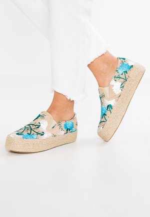 Ekspresowe buty wsuwane z haftem, z beżową tekstylną cholewką, ozdobioną niebieskimi i białymi kwiatowymi wzorami oraz plecioną, jutową podeszwą.