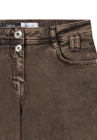 Pantaloni di jeans marroni con una texture liscia, dotati di due tasche frontali, una chiusura con bottone e un'etichetta di marca all'interno della vita.