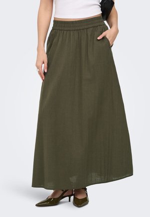 Moteris dėvi alyvuogių žaliai spalvos ilga sijoną su elastine juosmens dalimi, baltą trumpą viršutinę dalį ir alyvuogių žalios spalvos smailaus galo aukštakulnius, rankos – šonuose.