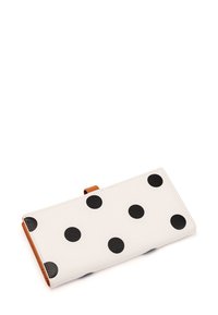 White wallet with large black polka dots, brown leather accent, smooth texture, and a flap closure. Compact, rectangular shape.