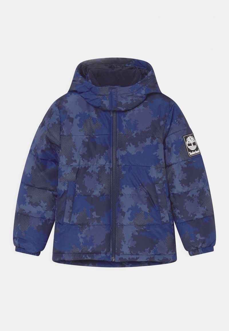 Modrá maskáčová prošívaná bunda s odnímatelnou kapucí, předním zapínáním na zip, bočními kapsami a nášivkou s logem na levé paži.