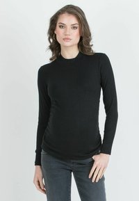 Black ribbed long-sleeve top with a high neckline, featuring a fitted design and side ruching. Fabric has a smooth texture.