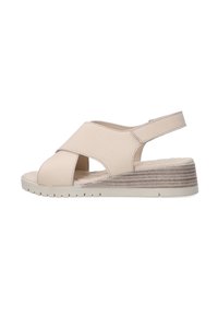 Beige wedge sandals with cross-strap design, open toe, and back strap. Textured wedged sole with horizontal lines. Soft material finish.