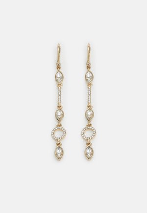 Boucles d’oreilles pendantes dorées avec cristaux taille marquise, un anneau circulaire de petits cristaux et fermoirs à levier sur fond blanc.