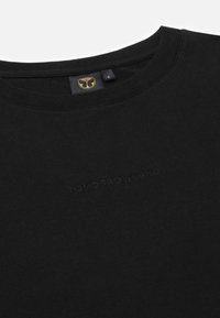 Zwarte t-shirt met een ronde hals en reliëftekst "TOMORROWLAND" op de voorkant. Gemaakt van zachte stof, met een label met logo.