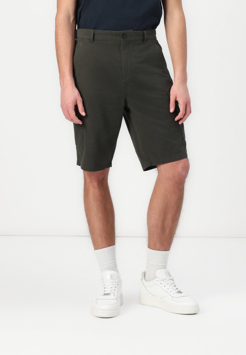 Shorts vert foncé avec une coupe droite, dotés d'une fermeture à bouton et de poches latérales. Fabriqués en tissu léger, adaptés pour une tenue décontractée.