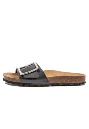 Sandale glissante en cuir noir avec une boucle métallique, semelle en liège et semelle antidérapante en caoutchouc. Présente un design lisse et plat.