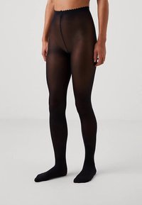 Zwarte ondoorzichtige panty's met een scallopvormige tailleband. Gladde textuur en aansluitend ontwerp, reikt tot aan de enkel met een naadloze uitstraling.