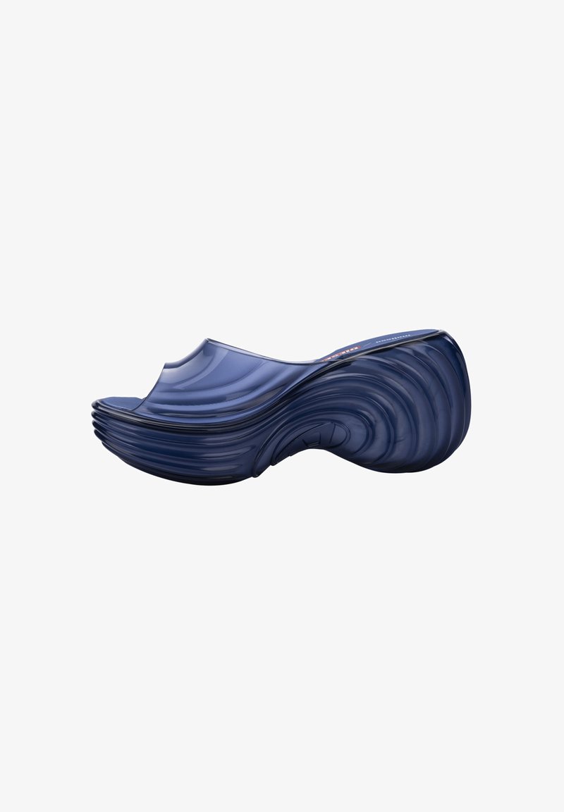 Sabot bleu marine, courbé ergonomiquement avec une semelle texturée en forme de vague et un design à bout ouvert.