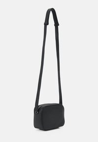 Borsa a tracolla in pelle nera con forma rettangolare, chiusura con zip e una sola tracolla regolabile. Texture liscia, design minimalista.