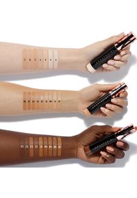 Anastasia foundationsticks getoond op drie armen, met verschillende tinten van licht tot diep. Elke tint is genummerd ter referentie.