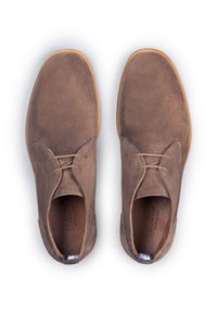 Scarpe in suede marrone con una texture liscia, design con lacci, punta arrotondata e suola in gomma a contrasto. Presentano un piccolo accento blu sul tallone.