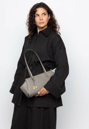 Gray handbag with a textured surface, semi-oval shape, gold hardware, and a dangling letter "P" charm, carried in a hand.