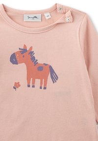 Rosa Baby-Overall mit Druckknöpfen an der Schulter, der ein Cartoon-Pferd mit blauer Mähne, Schwanz und Punkten zeigt, das neben einer kleinen Blume steht.