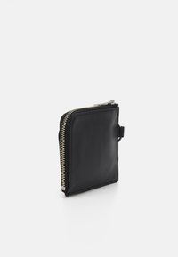 Portefeuille en cuir noir de forme carrée, avec une fermeture éclair dorée et une boucle latérale pour attache. Texture lisse, design minimaliste.