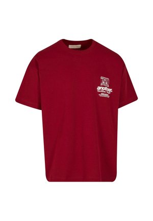 Burgundy cotton t-shirt with a crew neck, short sleeves, and a small white graphic text design on the left chest area.