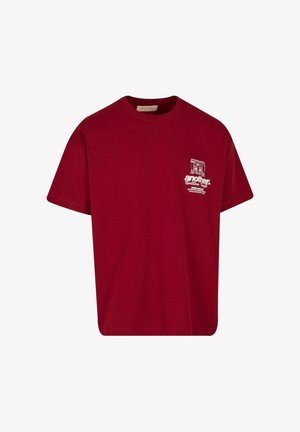 T-shirt in cotone bordeaux con collo rotondo, maniche corte e un piccolo design grafico in bianco sulla parte sinistra del petto.