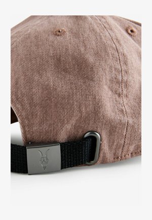 Căciulă din terci de culoare maro, cu o vizieră curbată, având o curea ajustabilă neagră și un accent metalic cu un design de craniu de țap.