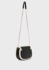 Svart axelväska med en plysch, krämfärgad kant. Har en slät läderexteriör, guld kedjesnodd och en klaffstängning.