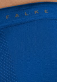 Blue athletic shorts with a textured pattern and elastic waistband, featuring the brand name "FALKE" printed in gray.