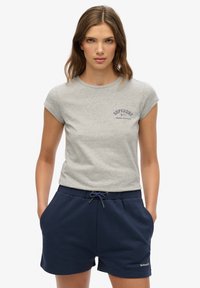 T-shirt en coton gris à manches courtes avec un logo bleu et shorts de sport bleu marine avec une taille élastique et un cordon de serrage.