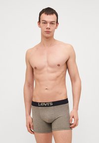 Herren Boxer aus meliertem Graufabric, mit einem breiten, marineblauen Bund, der das "Levi's"-Logo trägt. Enganliegender Stil mit glatter Textur.