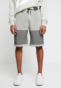 Grå och svart rutig shorts med ett halvrutigt mönster, elastisk midja med dragsko och uppvikta fållar.