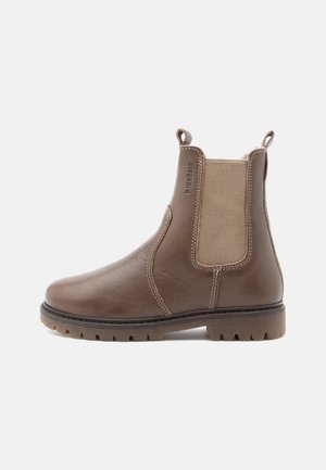 Bruine leren Chelsea boot met elastische zijkanten en trekriemen, voorzien van een robuuste rubberen zool en gedetailleerde stiksels.
