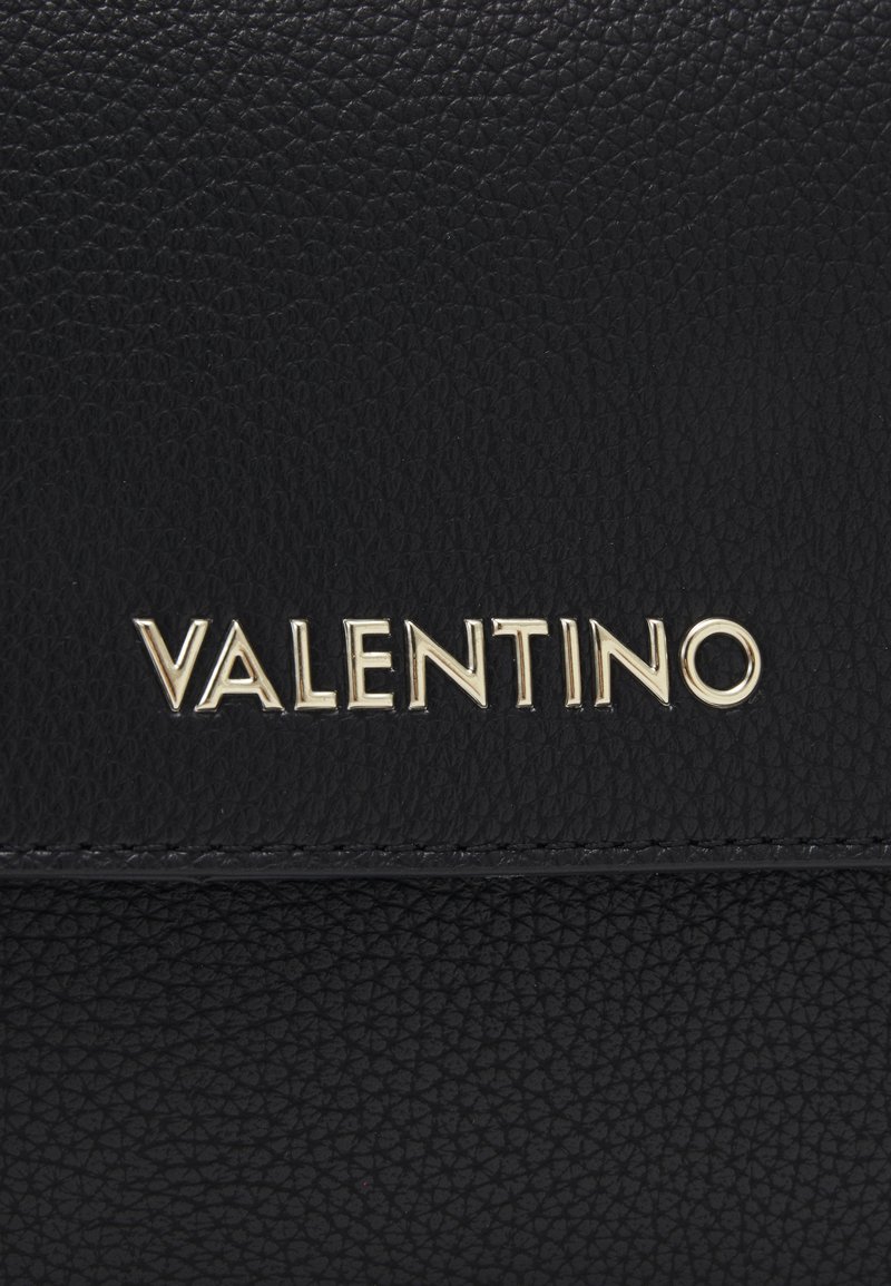 Portefeuille en cuir noir texturé avec un logo "VALENTINO" doré. La surface présente un motif subtil avec des accents cousus.